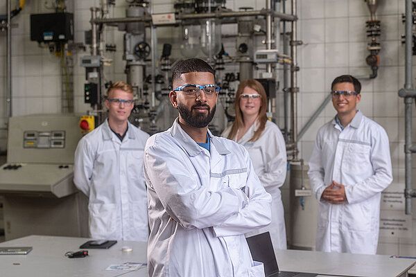 Vier Personen in Laborkleidung